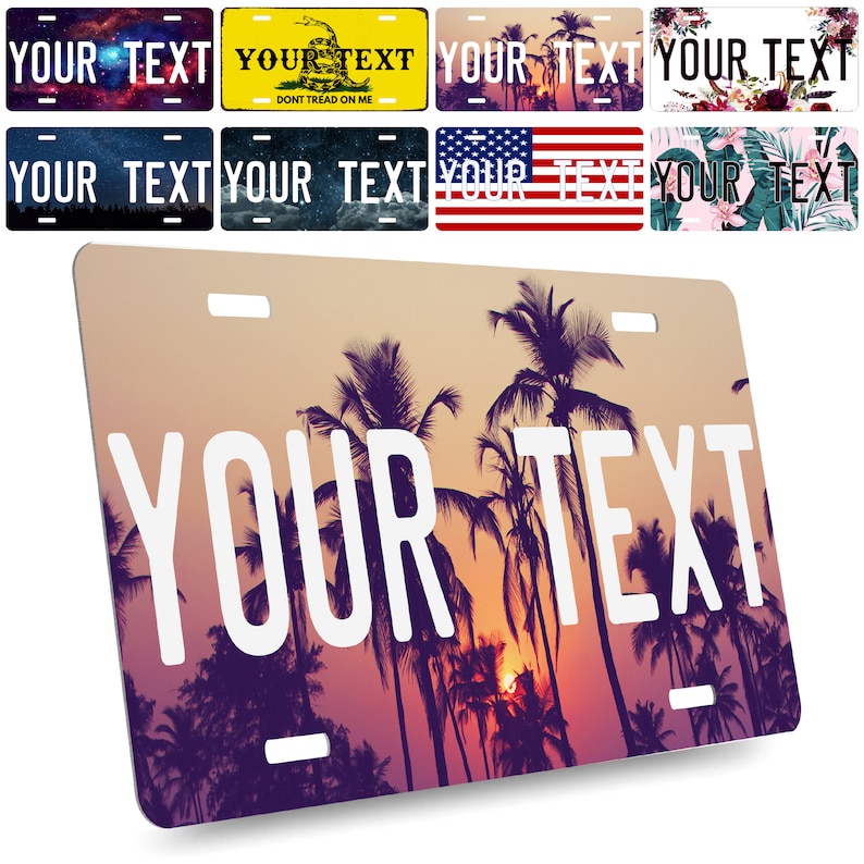 May include: A personalized license plate featuring a sunset scene with palm trees silhouetted against a pink and orange sky. The text "YOUR TEXT" is printed in white on the plate.