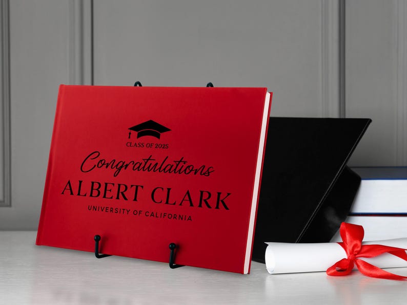 May include: Red graduation guest book with black text that reads "Congratulations Albert Clark, University of California, Class of 2023".