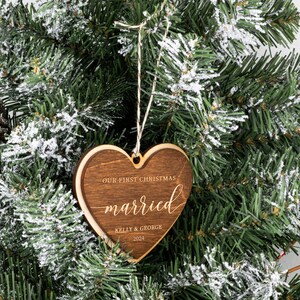 May include: A wooden heart-shaped Christmas ornament with the text "Our First Christmas Married Kelly & George 2024".