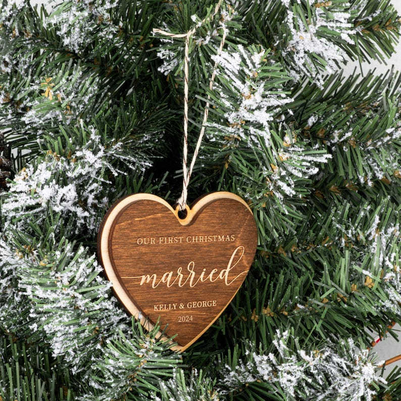 May include: A wooden heart-shaped Christmas ornament with the text "Our First Christmas Married Kelly & George 2024".