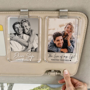May include: Two clear acrylic photo holders attached to a car visor. Each holder contains a black and white photo of a couple. One reads "Drive Safe" and the other reads "The Love of my Life!"