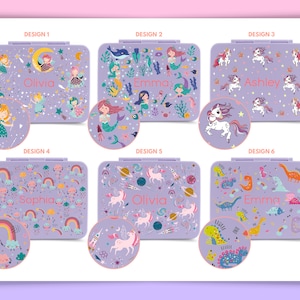 May include: Six different designs for personalized lunch boxes. Each design features a different theme, including unicorns, mermaids, rainbows, and dinosaurs. The lunch boxes are purple with a white border and a clear plastic window. The names Olivia, Emma, Ashley, and Sophia are printed on the lunch boxes.