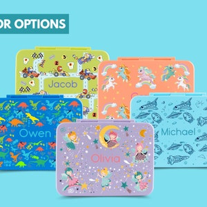 May include: Five colorful lunchboxes with different designs. The lunchboxes feature a variety of themes, including dinosaurs, race cars, fairies, unicorns, and spaceships. Each lunchbox has a personalized name on the front: Owen, Jacob, Olivia, Michael.