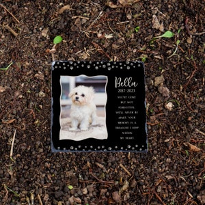 May include: Black slate memorial stone with a white dog photo, paw prints, and the text "Bella 2017-2023 You're gone but not forgotten. We'll never be apart. Your memory is a treasure I keep within my heart."