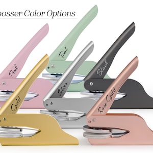 May include: An assortment of embosser seals in various colors, including pink, gold, teal, silver, black, and rose gold. Each embosser features a handle with the color name printed on it. The text "Embosser Color Options" is at the top.