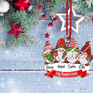 May include: A Christmas ornament featuring four gnomes with red hats and white beards. The gnomes are holding gifts and candy canes. The ornament has a red ribbon and a silver star. The names "James, Abigail, Sophia, Kelly" and "THE HARRISONS" are printed on the ornament.