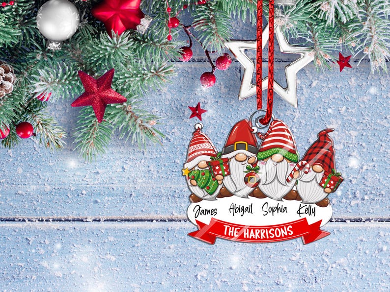 May include: A Christmas ornament featuring four gnomes with red hats and white beards. The gnomes are holding gifts and candy canes. The ornament has a red ribbon and a silver star. The names "James, Abigail, Sophia, Kelly" and "THE HARRISONS" are printed on the ornament.