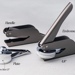 May include: Three gray metal embossers with silver accents are displayed. The largest embosser is 5.1 inches tall and 4.8 inches wide. The plate has a maximum size of 1.5 inches. The image includes the words "Handle", "Embosser", and "Plate".