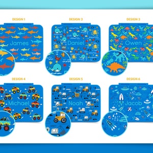 May include: Six different designs for personalized lunchboxes. Each lunchbox features a different pattern, including sharks, ocean life, dinosaurs, monster trucks, construction vehicles, and spaceships. The lunchboxes are all blue with white and yellow accents. The names James, Daniel, Owen, Michael, Noah, and Jacob are printed on the lunchboxes.