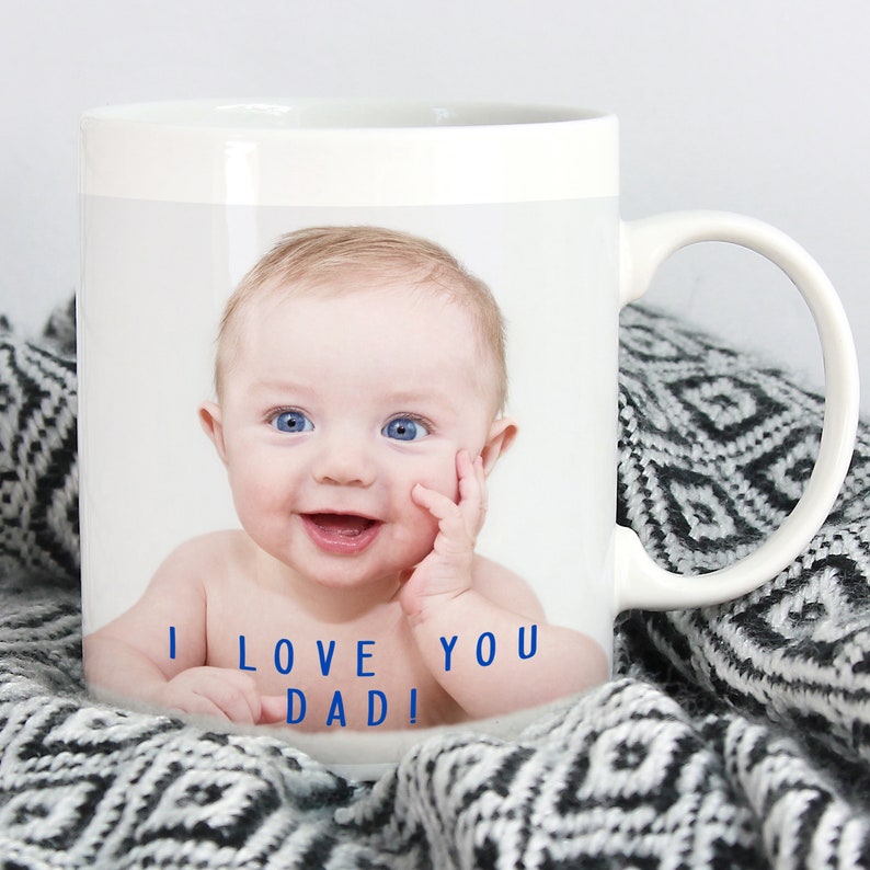 May include: White ceramic mug with a photo of a baby smiling and the text "I love you Dad!" printed in blue.