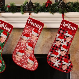 May include: Three red Christmas stockings with personalized names, Penny, Arthur, and Ashley. Each stocking features a different pattern and a photo of a person's face.
