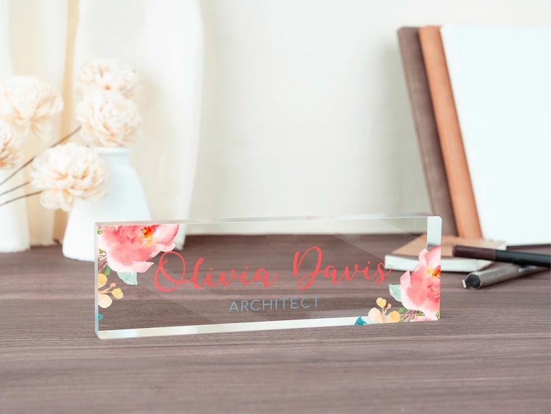 May include: A clear acrylic desk nameplate with a floral design and the text "Olivia Davis, Architect".