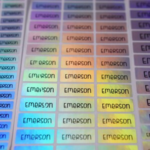 May include: A sheet of iridescent holographic labels with the name "Emerson" printed in black on each label.