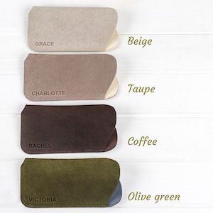 Peut inclure: Quatre &eacute;tuis &agrave; lunettes en daim beige, taupe, caf&eacute; et vert olive. Chaque &eacute;tui a un int&eacute;rieur contrast&eacute; et un nom imprim&eacute; sur le devant : Grace, Charlotte, Rachel et Victoria. Les &eacute;tuis sont pr&eacute;sent&eacute;s sur une surface en bois blanc.