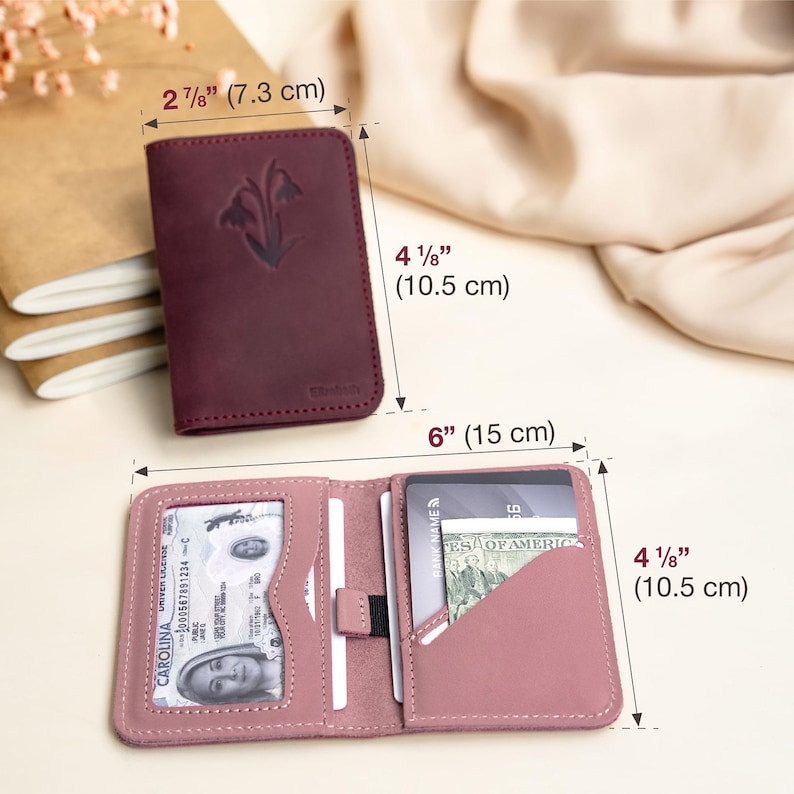 May include: A burgundy leather wallet, 2 7/8 inches by 4 1/8 inches (7.3 cm x 10.5 cm), with a floral design. The open wallet, 6 inches by 4 1/8 inches (15 cm x 10.5 cm), reveals card slots and a clear ID window. The wallet is a dusty rose color.