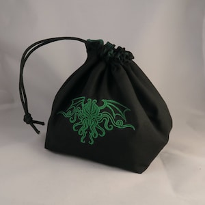 Reversible drawstring dice bag with toggle closure and square base. Ideal for D&D, board games, wargames. Features embroidered design and plain color side. Great gift for tabletop gamers