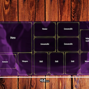 May include: A purple gaming mat with a grid layout for organizing cards and tokens. The mat has sections labeled "Hero", "Armor", "Weapon", "Skill", "Consumable", "Trinket", "Help Card", and "Wound".
