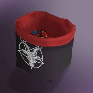 Può includere: Un sacchetto dadi nero e rosso con un design a testa di capra bianca. Il sacchetto è fatto di tessuto e ha una chiusura con coulisse.