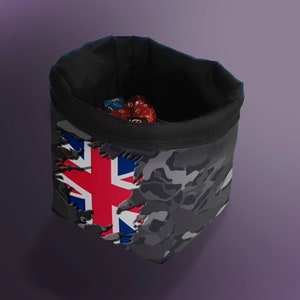 May include: A black dice bag with a camouflage pattern and a torn section revealing a Union Jack flag. The bag is filled with red, blue, and yellow dice.