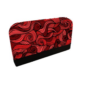 May include: A rectangular object with a black base and a top covered in a red and dark red swirling pattern. The design features flowing lines and spiral shapes, creating a dynamic visual effect.