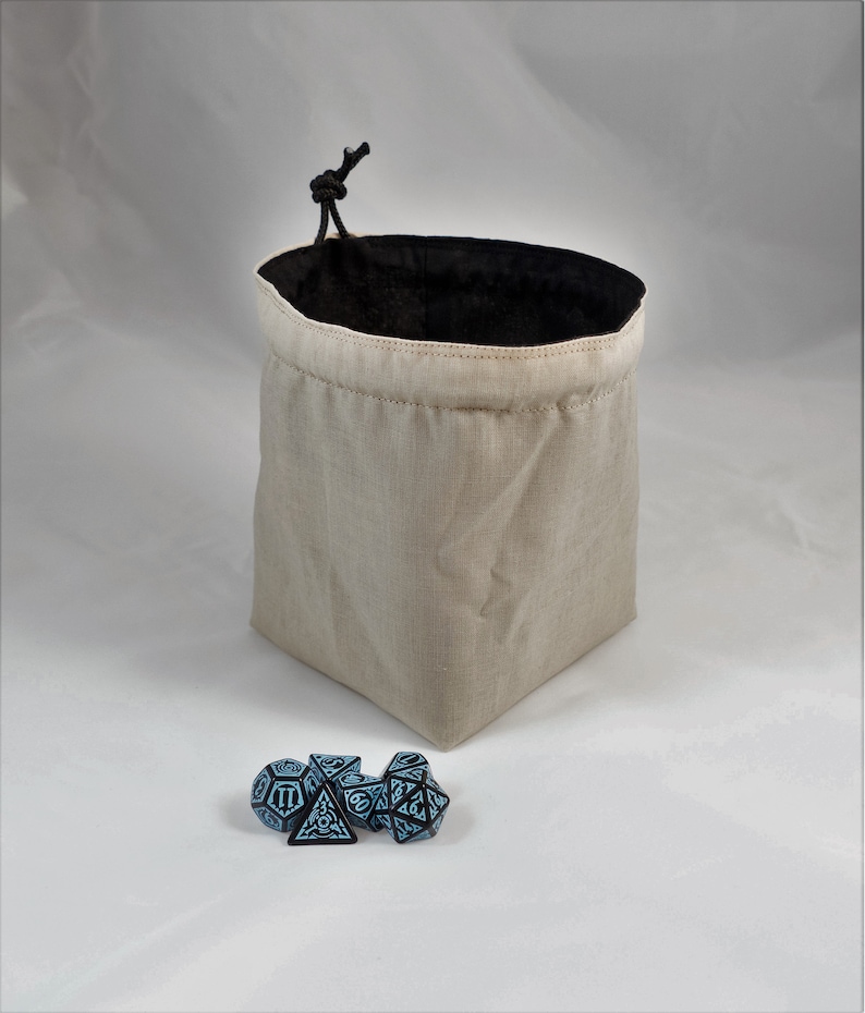 Reversible drawstring dice bag with toggle closure and square base. Ideal for D&D, board games, wargames. Features embroidered design and plain color side. Great gift for tabletop gamers
