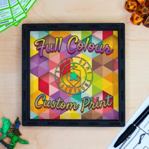May include: A black frame with a colorful geometric pattern and the text "Full Colour Custom Print". The frame has a logo in the center that says "Board Game Solutions".