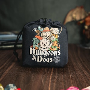 May include: Black drawstring bag with a white graphic of dogs dressed as Dungeons & Dragons characters. The bag has the text "Dungeons & Dogs" in white with a 20-sided die graphic.