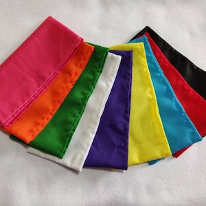 May include: A set of ten fabric squares in various colors, including pink, orange, green, white, purple, yellow, blue, red, and black. The squares are folded and arranged in a fan shape.
