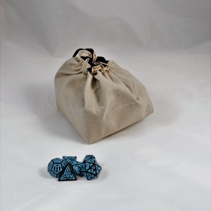 Reversible drawstring dice bag with toggle closure and square base. Ideal for D&D, board games, wargames. Features embroidered design and plain color side. Great gift for tabletop gamers