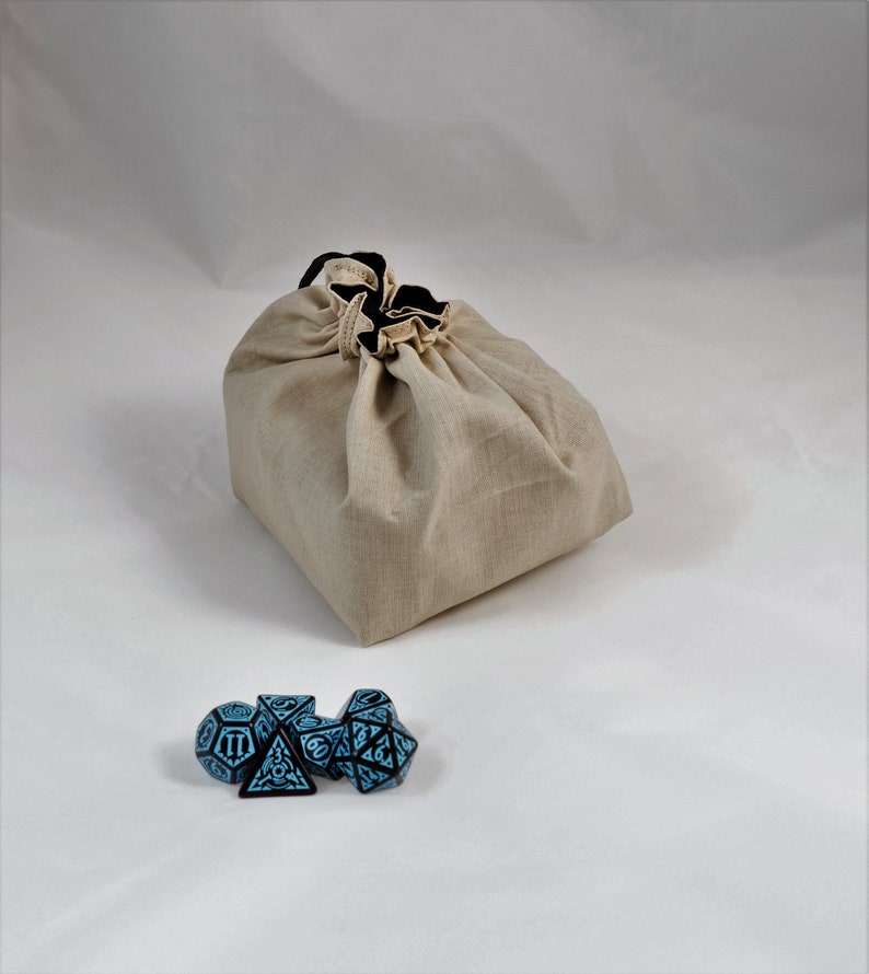 Reversible drawstring dice bag with toggle closure and square base. Ideal for D&D, board games, wargames. Features embroidered design and plain color side. Great gift for tabletop gamers