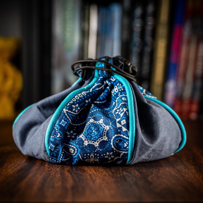 Extra-large freestanding drawstring dice bag with plush suede lining and twin storage pockets, crafted to hold 200+ dice plus tokens, counters and mini accessories – practical upgrade for RPG and board-game players.
Great Christmas or birthday gift for fans of Dungeons & Dragons, Pathfinder, Starfinder, Warhammer 40k, Age of Sigmar, Arkham Horror LCG, Star Wars Unlimited, Pokémon TCG, Disney Lorcana, Magic the Gathering, Gloomhaven, Frosthaven, Everdell, Cascadia, Terraforming Mars