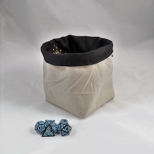 Reversible drawstring dice bag with toggle closure and square base. Ideal for D&D, board games, wargames. Features embroidered design and plain color side. Great gift for tabletop gamers