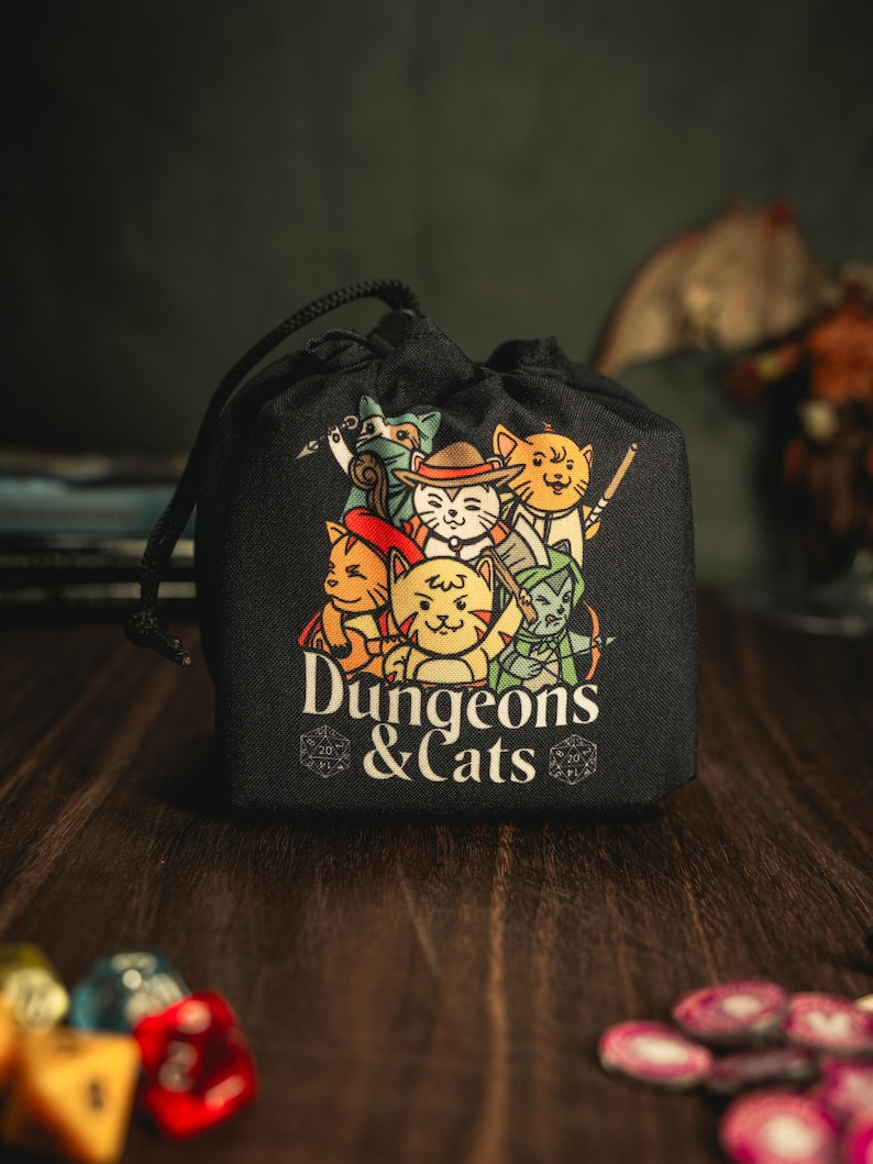 Cat Dice Bag for DND – Gift for Gamers and Cat Lovers!
Bring a touch of feline charm to your next Dungeons & Dragons session with this handcrafted Cat Dice Bag, featuring a whimsical Dungeons and Cats tile pattern.
🧵 Soft, durable cotton blend exterior with a secure drawstring closure
🎁 Great gift for D&D players, cat lovers, and geeky gamers
🖐️ Handmade with care in the UK
Makes a quirky stocking stuffer, birthday gift, or surprise treat for your party’s bard, rogue, or dungeon master.