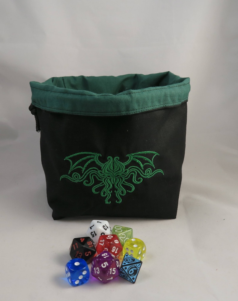 Reversible drawstring dice bag with toggle closure and square base. Ideal for D&D, board games, wargames. Features embroidered design and plain color side. Great gift for tabletop gamers