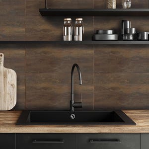 May include: A black kitchen sink with a black faucet against a brown tile backsplash. The backsplash has a rustic, industrial look. There are two shelves above the sink, one with glass jars and the other with black dishes.