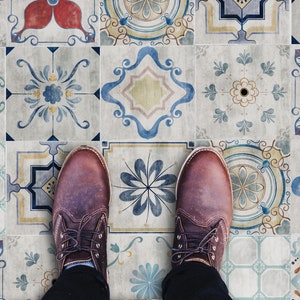 May include: A pair of brown leather shoes with laces stand on a patterned tile floor. The tiles are a mix of blue, yellow, red, and white with intricate designs.