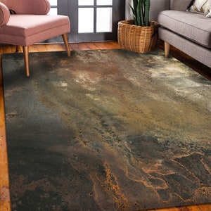 Puede incluir: Alfombra de área abstracta con un esquema de color marrón, gris y dorado. La alfombra tiene un aspecto desgastado y desgastado, con patrones y texturas en espiral.