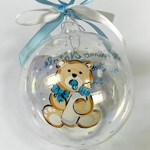 Baby's eerste kerst, gepersonaliseerd ornament met naam en teddybeer. Handbeschilderd item, verkrijgbaar in roze, lichtblauw en rood.
