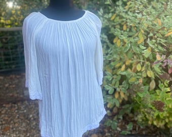 May include: White, lightweight, semi-sheer,  cotton top with a gathered neckline and lace trim. The top has 3/4 sleeves and a loose, flowy fit.