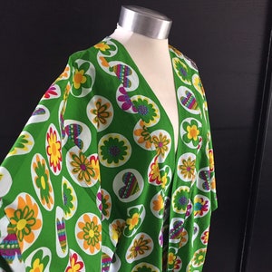 K&ouml;nnte beinhalten: Ein gr&uuml;nes Kimono mit Blumen- und Herzprint. Der Druck zeigt gelbe, orange, rote, rosa, gr&uuml;ne und blaue Farben.