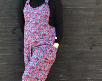 May include: A red and blue jumpsuit with a starfish pattern. The jumpsuit has a wide leg and a scoop neck. The straps are tied at the shoulders.