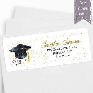 May include: White graduation address label with gold accents. Features a watercolor graduation cap and the text "Jonathan Swanson" with address details. Includes "Class of 2026" and "Any class year".