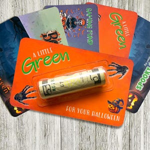 Puede incluir: Una colección de tarjeteros rectangulares con temática de Halloween en fondos naranjas, morados y azul oscuro. Cada tarjeta presenta gráficos festivos como calabazas, arañas y esqueletos, con el texto A LITTLE GREEN FOR YOUR HALLOWEEN.