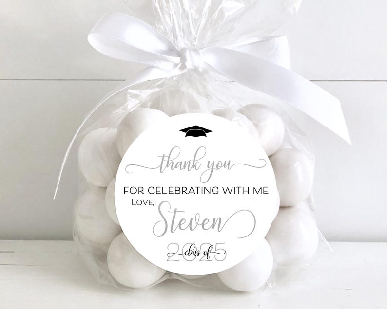 May include: White favor bags filled with white candy and a round white sticker with black text that says "Thank you for celebrating with me, Love, Steven, Class of 2025".