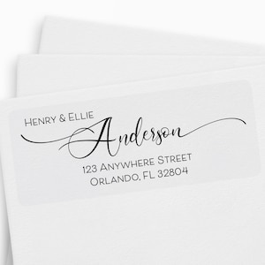 May include: A white return address label with black text. The text reads "Henry & Ellie Anderson", "123 Anywhere Street", and "Orlando, FL 32804".
