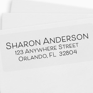 May include: A white return address label with black text that reads "SHARON ANDERSON, 123 ANYWHERE STREET, ORLANDO, FL 32804".