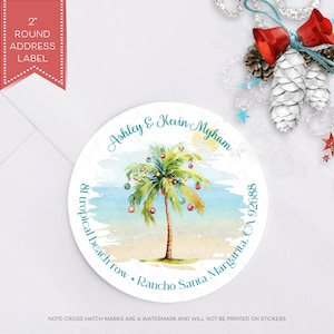 May include: A white round address label with a watercolor illustration of a palm tree with red and green ornaments. The text "Ashley & Kevin Myham 81 tropical beach row Rancho Santa Margarita, CA 92688" is printed in teal blue.