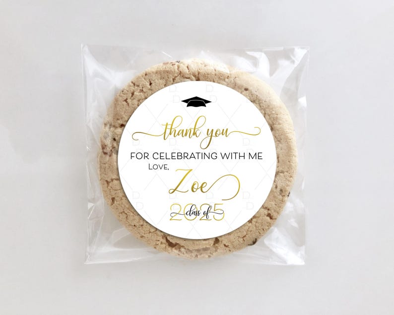 May include: White round sticker with black and gold text. The sticker says "Thank you for celebrating with me. Love, Zoe Class of 2025". A black graduation cap icon is above the text. The sticker is on a brown cookie.