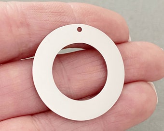 May include: A white metal circle with a hole in the top. The circle has a smaller circle cut out of the center.