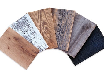 May include: Six wood samples in various shades of brown, gray, and black. The samples are arranged in a fan shape, with the darkest sample at the bottom and the lightest sample at the top.
